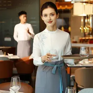 Smiling waitress holding a tray and serving water in a restaurant